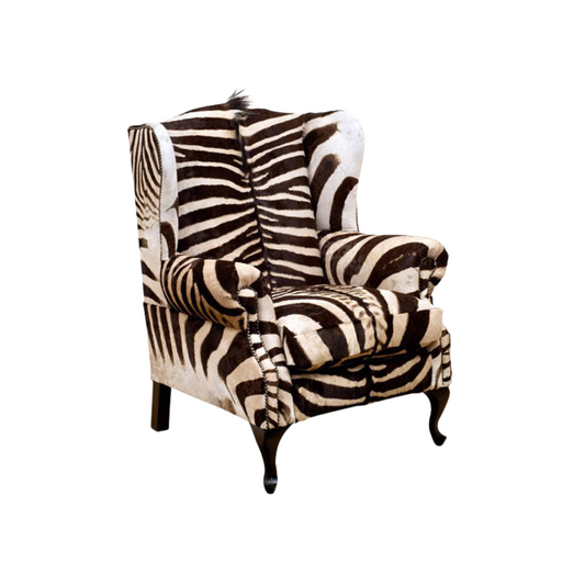 Burchell Zebra Wingback Armchair – An African Statement Masterpiece. Elevate your space with this striking wingback armchair, adorned in Burchell Zebra. Crafted to make a bold statement, it is a unique blend of style and African authenticity.  International export of Burchell Zebra available. Customize this masterpiece with your choice of hair-on hides, skins, or fabrics. Pricing available upon request for a truly bespoke creation.