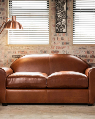 Cuba Sofa – Channel the ambiance of Havana's cigar lounges with the Cuba Sofa. Featuring a low-profile sprung back and soft-filled cushions, it offers the perfect spot for kicking back and chilling.  Tailor your space with custom sizes and your preferred premium leather or fabric, ensuring a personalized touch that captures the essence of relaxation and style.